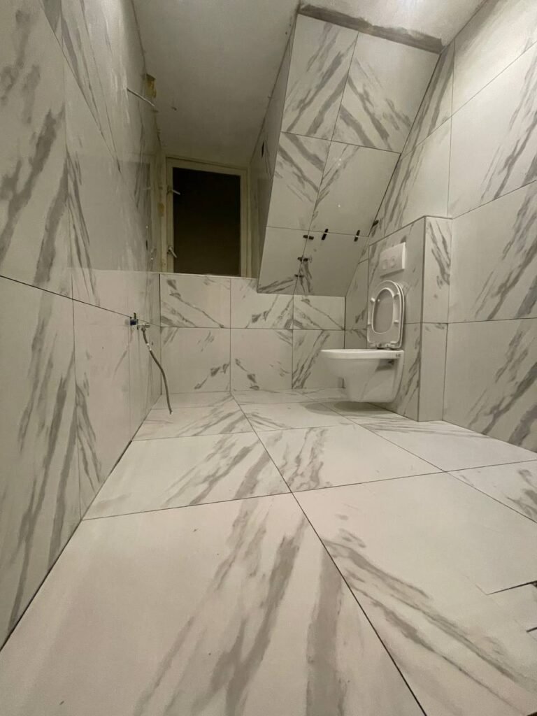 Moderne badkamer renovatie met ruime inloopdouche en grijze tegels